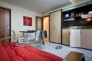 a living room with a red couch and a kitchen at Casa Vacanze Samira in Fondachello