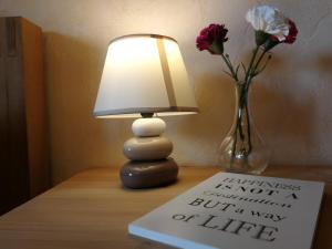 a lamp sitting on a table next to a vase with flowers at Wandertraum Johann - FeWo Eifel in Kruft