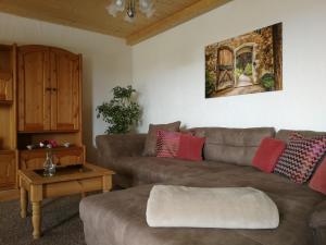 ein Wohnzimmer mit einem Sofa und einem Tisch in der Unterkunft Wandertraum Johann - FeWo Eifel in Kruft