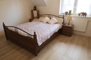 1 dormitorio con cama de madera y almohadas en Lawendowa Galeria, en Krapkowice