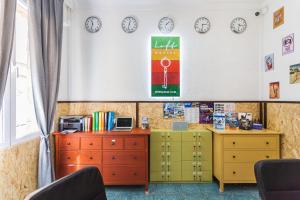 a classroom with clocks on the wall and a desk at LOFT Hostal in Lloret de Mar