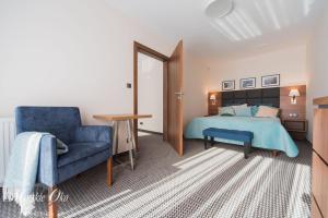 1 dormitorio con 1 cama azul y 1 silla azul en villa Morskie Oko en Pogorzelica