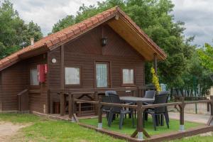 a cabin with chairs and a table in front of it at Camping Gironella in Gironella