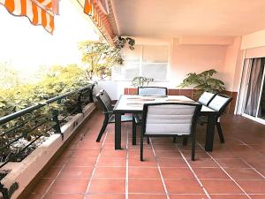 una mesa y sillas en un balcón con plantas en Apartament Guadalmina en Marbella