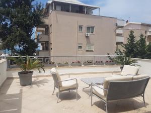 a patio with chairs and a table and a building at Villa Sol & Mar in Golem