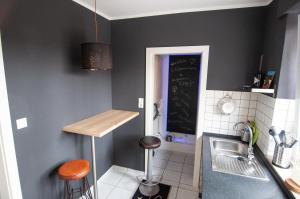 a kitchen with a sink and a counter with stools at Beverlodge in Telgte