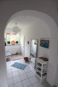 um quarto com piso em azulejo branco e um arco em Beverlodge em Telgte