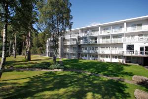 an apartment building with a lawn in front of it at Rosfjord Strandhotel in Lyngdal