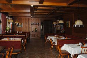 un comedor con mesas, sillas y luces colgantes en Gasthof Kaiserblick, en Breitenbach am Inn