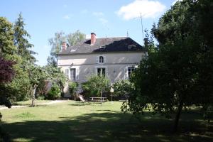 una gran casa blanca con una mesa de picnic en el patio en L'Ecrin du Serein, en Sainte-Vertu