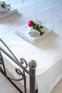 a white bed with a napkin with a rose on it at Harma - Grand Sea & Mountains View in Exopoli