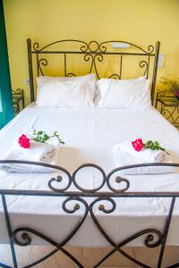 a bed with white sheets and red roses on it at Harma - Grand Sea & Mountains View in Exopoli
