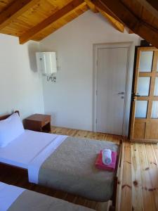 ein Schlafzimmer mit einem Bett und einem rosa Handtuch darauf in der Unterkunft Apartmani Vinici in Danilovgrad