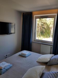 ein Schlafzimmer mit einem Bett mit zwei Handtüchern darauf in der Unterkunft Apartamentdziwnówek in Dziwnówek