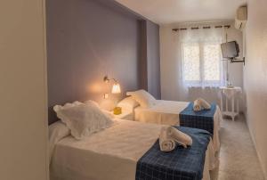 a bedroom with two beds with towels on them at Hostal Arribes del Duero in Fermoselle