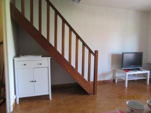 sala de estar con escalera y TV en Au calme Residence l'ile heureuse en Les Lecques