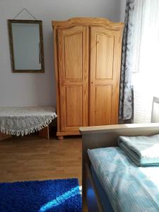 1 dormitorio con armario de madera y alfombra azul en U Danusi en Wroclaw