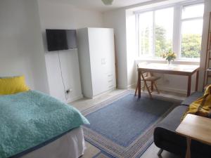 a bedroom with a bed and a desk and a table at Close to Beach and Town Square in Bournemouth