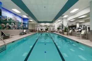 uma grande piscina com água azul num edifício em Fairmont Washington DC Gold Experience em Washington