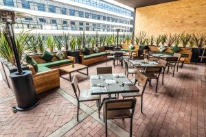 a patio with tables and couches and chairs at GHL Hotel Bogota Occidente in Bogotá