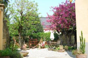 a garden with trees and chairs and purple flowers at Colazione da Augusta - Guesthouse in Turin