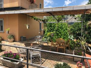 een patio met stoelen, tafels en planten bij B&b VerdeMare Camerota in Camerota