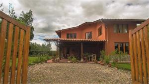 una casa naranja con una puerta y un patio en Los Jardines de Teresa, en Cajamarca