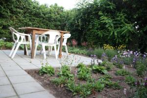 due sedie e un tavolo in un giardino fiorito di Logerenbijonsz a Berghem