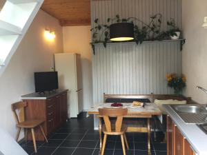 a small kitchen with a table and a refrigerator at Domek Wakacyjny in Mikołajki