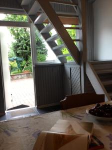 una habitación con una puerta abierta y una mesa con un tazón de uvas en Domek Wakacyjny en Mikołajki