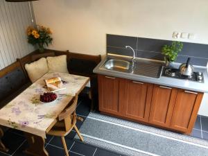 a small kitchen with a table and a sink at Domek Wakacyjny in Mikołajki