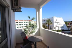 a balcony with a table and chairs and a window at APARTAMENTO MICÁ in Albufeira