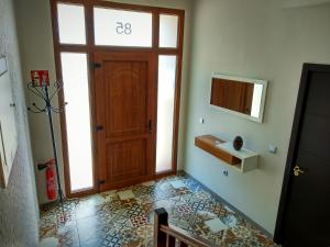 a hallway with a wooden door and a tile floor at Casa Rural El Caño in Nava del Rey