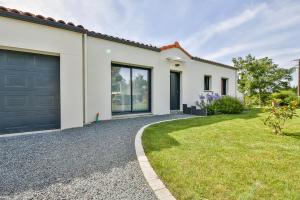 ein weißes Haus mit Auffahrt und Garage in der Unterkunft Villa d'Eau Douce in La Mothe-Achard