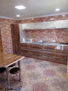 een keuken met houten kasten en een houten tafel bij Tskaltubo Apartment Meri in Tskaltubo