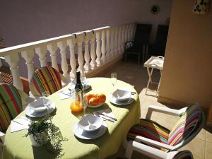 オリフエラ・コスタにあるAppartement Campoamor Beach, Orihuela Costaの黄色のテーブルクロスとワイン1本付きのテーブル