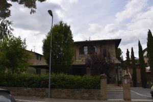 a house with a street light in front of it at La Torre Rooms in San Quirico dʼOrcia