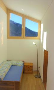 a bedroom with a bed and two windows at Haus Diezig in Blitzingen