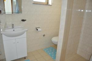 a bathroom with a sink and a toilet at Apartments Alicia Lopar-50m vom Strand in Lopar
