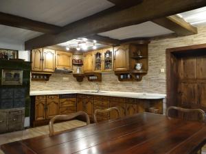 a kitchen with wooden cabinets and a wooden table at Prázdninový dům Nové Hraběcí in Šluknov