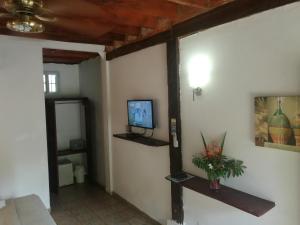 sala de estar con TV en la pared en Hotel Gerald en Contadora