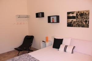 a bedroom with a bed with a chair and pictures on the wall at Valderice Rio Apartments in Valderice