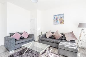 a living room with two couches and a glass table at Casa Fresa - Cowgate Apartment in Dundee