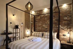 a bedroom with a bed and a brick wall at LA MAESTA' in Langhirano