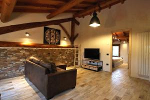 a living room with a couch and a television at LA MAESTA' in Langhirano