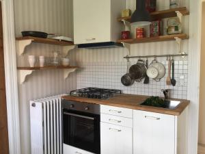 uma cozinha com armários brancos e um forno com placa de fogão em Villa Valby em Copenhague
