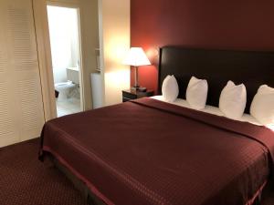 a hotel room with a large bed with white pillows at Regal Inn Chicago O'Hare - Franklin Park in Franklin Park