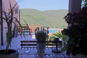 a table with potted plants on a patio with a view at Apartments Palma Rabac in Rabac