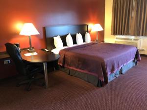 a hotel room with a bed and a desk at Regal Inn Chicago O'Hare - Franklin Park in Franklin Park