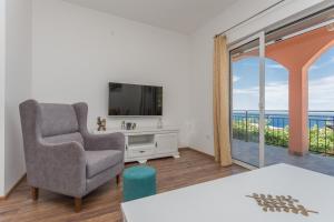 a living room with a chair and a television at Apartments Natasa in Sveti Stefan